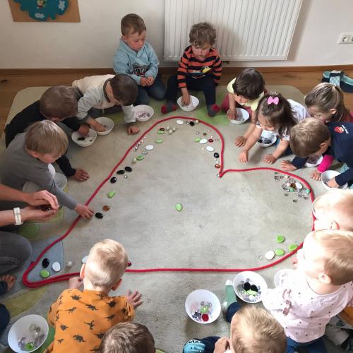 Wir schmücken das Herz mit buten Steinen.